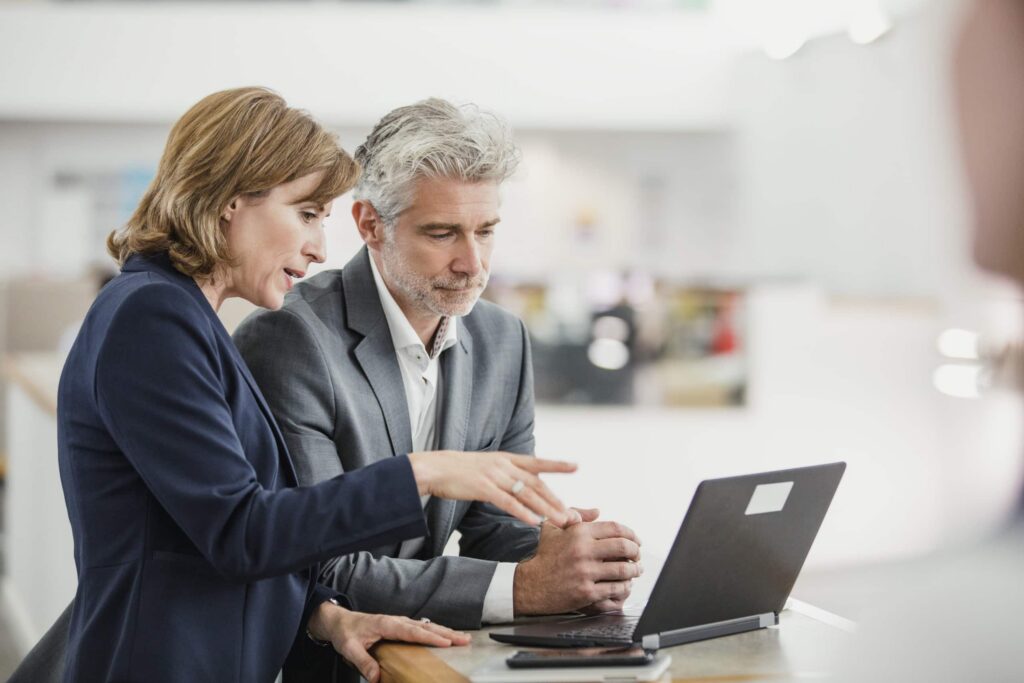 Colleagues discussing a project looking at laptop