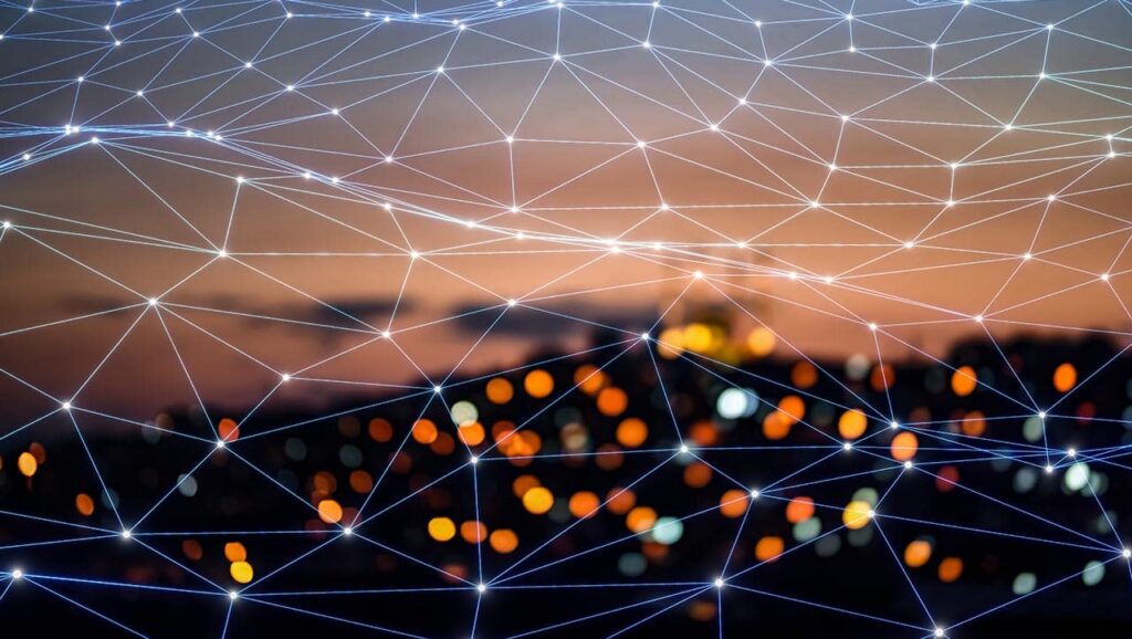 A digital network of interconnected lines and nodes overlays a blurred cityscape at dusk, with glowing bokeh lights enriching data in the background, creating a sense of connectivity and modern technology. ©Mobysoft