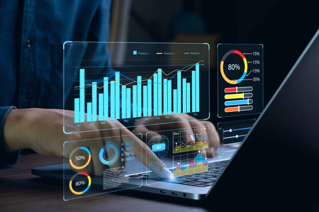 Hands interact with a laptop featuring holographic charts and graphs. Displays include bar graphs, pie charts, and percentage data, each showing diverse analytics essential for data-driven social housing repairs, reflecting advanced data visualization or financial analysis. ©Mobysoft
