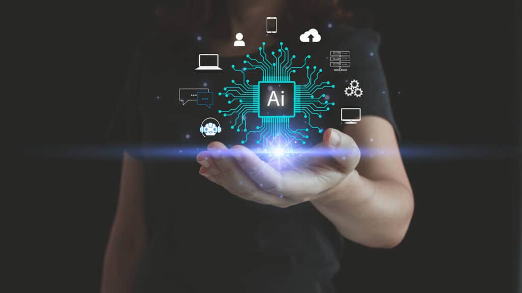 A person holds out their hand with a glowing digital icon labeled "AI" at the center. Surrounding it are various tech symbols, such as a smartphone, laptop, and chat bubbles, representing technological connectivity and innovation. ©Mobysoft