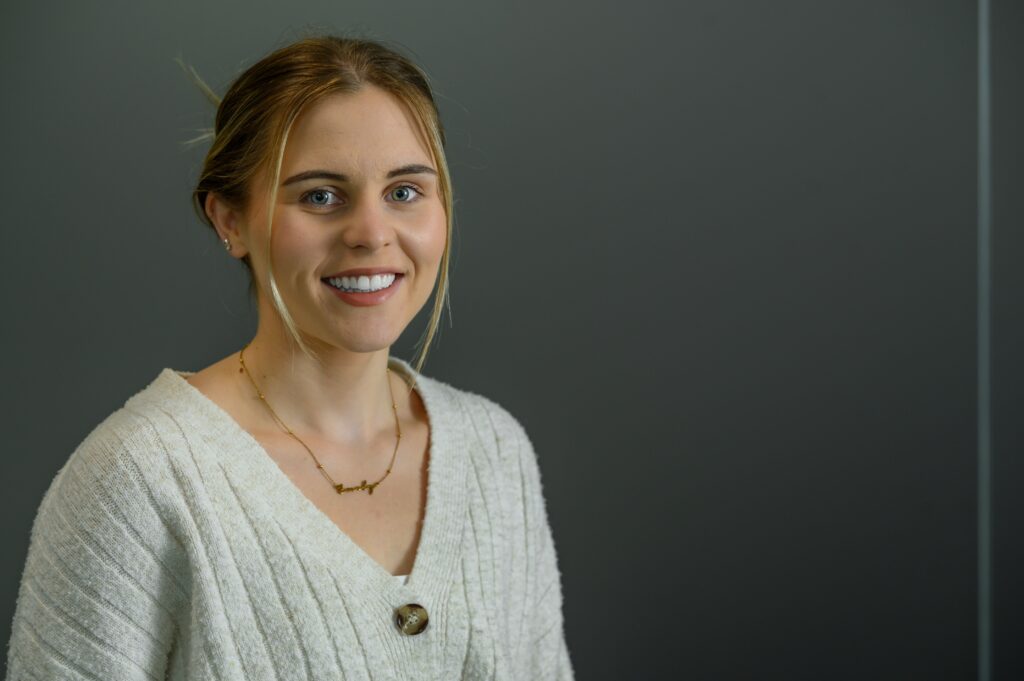 Emily Cobby standing infront of a gray background